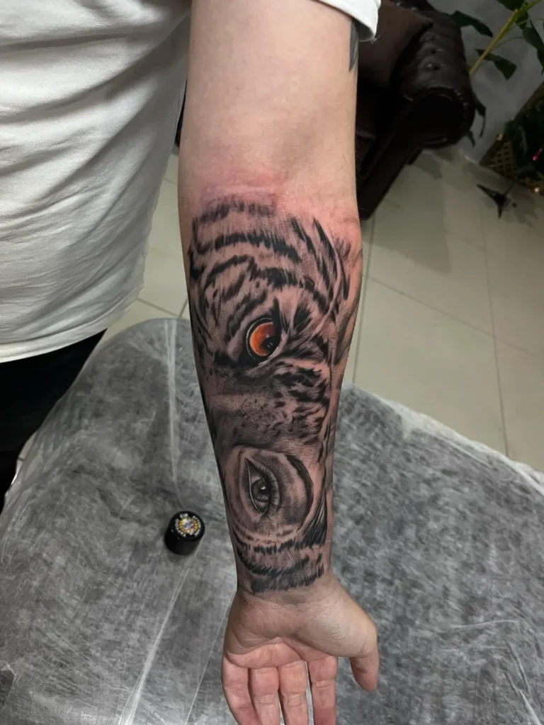 Erkek iç kol bölgesine uygulanmış, siyah ve gri tonlarda detaylandırılmış realist baykuş dövmesi çalışması.